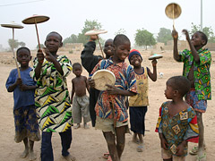 A group of children smiling, playing with plates on sticks.