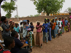 People lined up at an outdoor field clinic for vaccine.